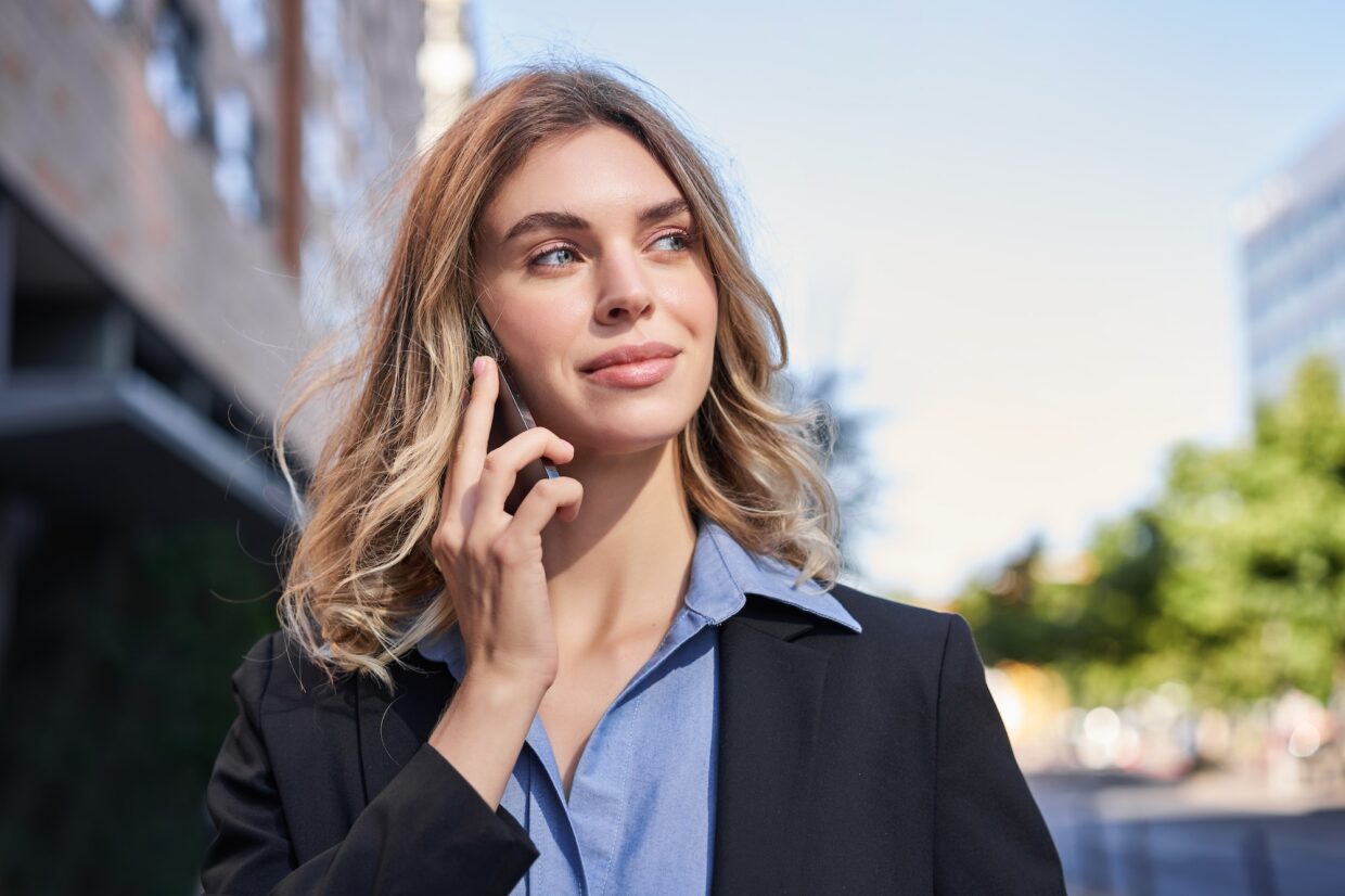 Close up portrait of smiling saleswoman, successful female manager having phone call, answer