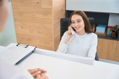 Joyous young female receptionist in her workplace