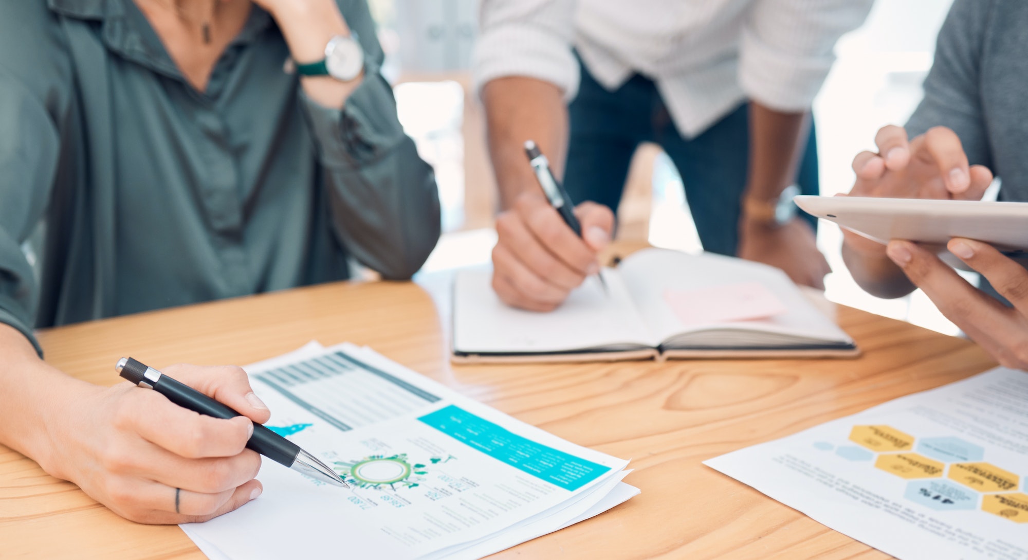 Business, group and hands for data on chart, analytics and graph for analytics in finance on desk.