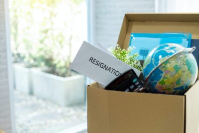 Resignation letter and cardboard box on the desk. Concept of termination of employment