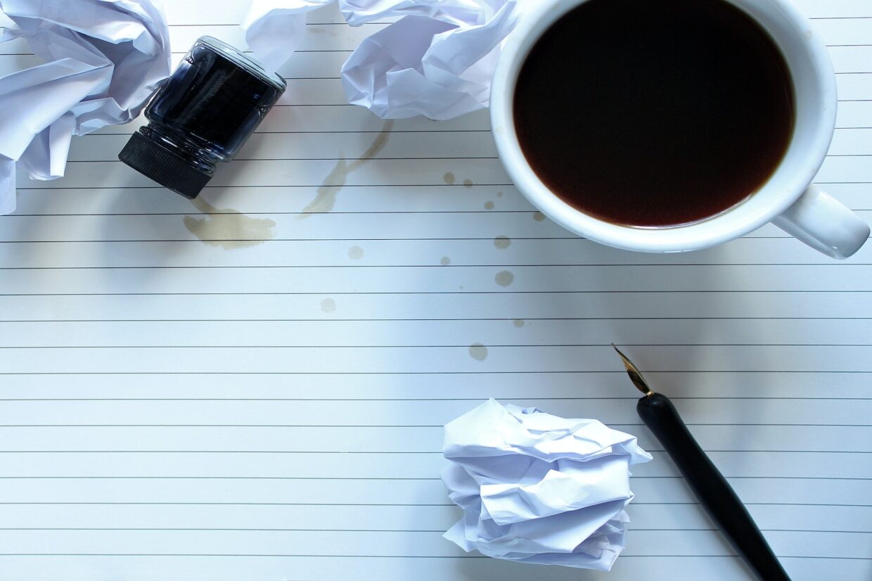 Writers block concept with blank paper, pen coffee and crinkled paper